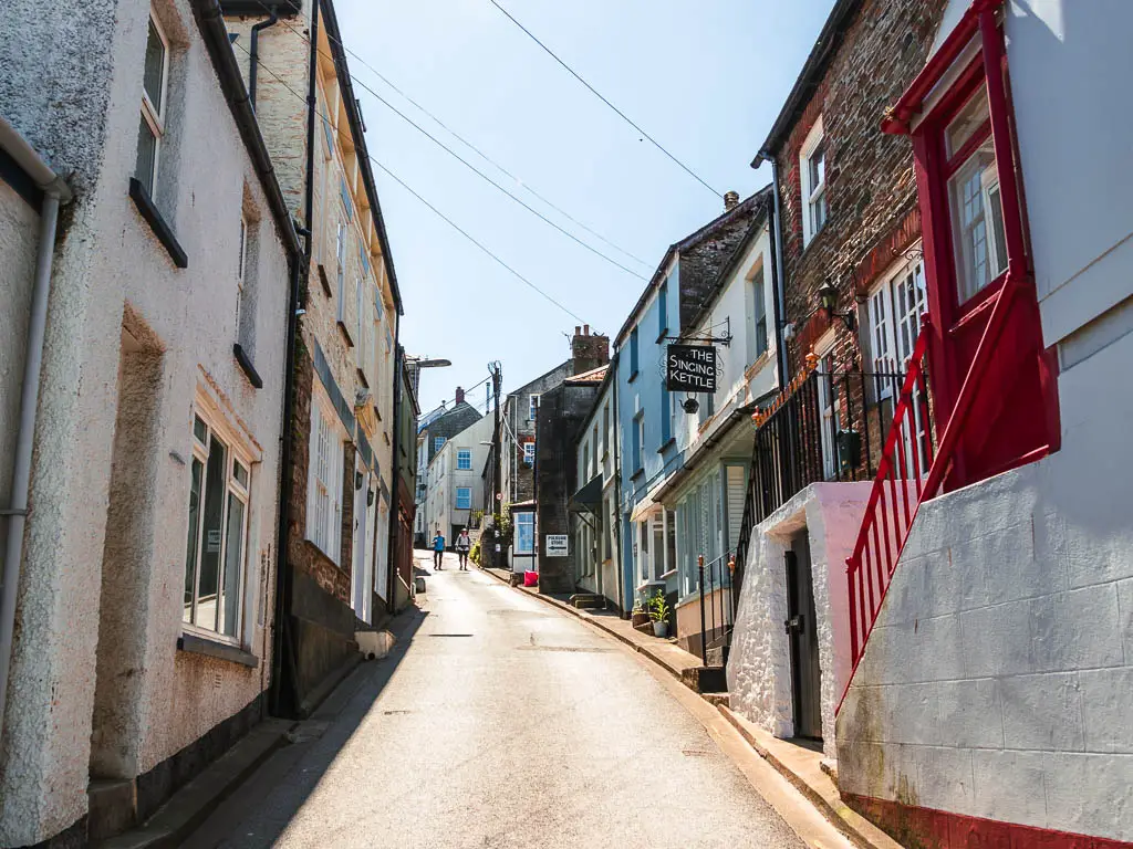 Looking uphill along the narrow street lined with houses and shops in Polruan.