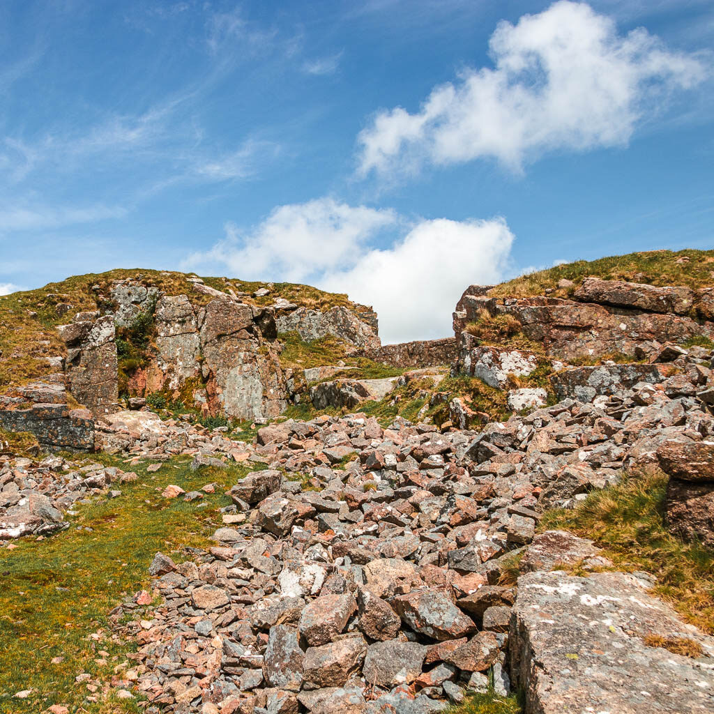 Looking up across lots of rocks to the tors ahead.