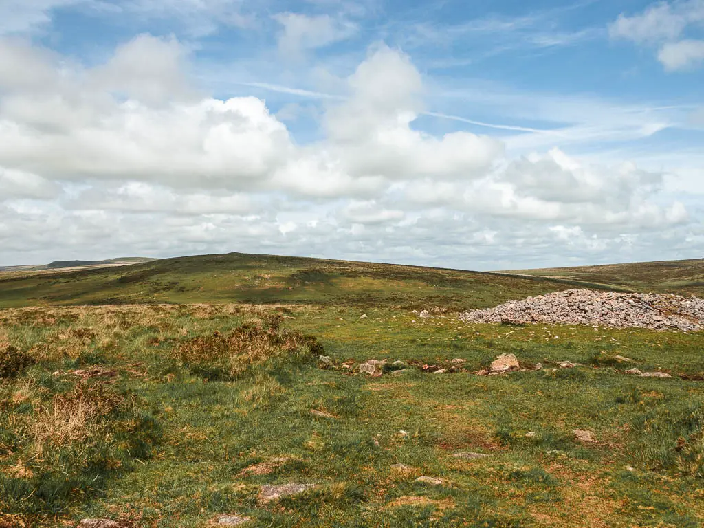 Looking across the grass towards a hill in the distance on the Ivybridge Western Beacon walk.