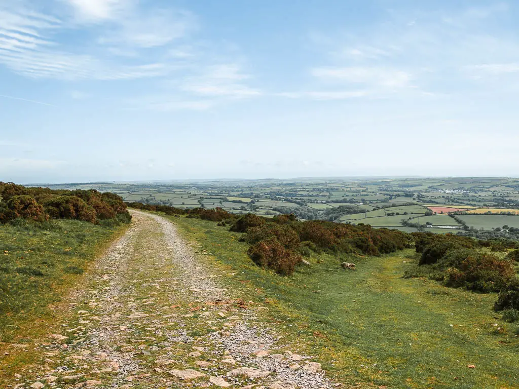 The Redlake tramway leading to the left with a grass trail leading off it to the right, near the end of the walk. There are fields down the hill in the distance to the right.