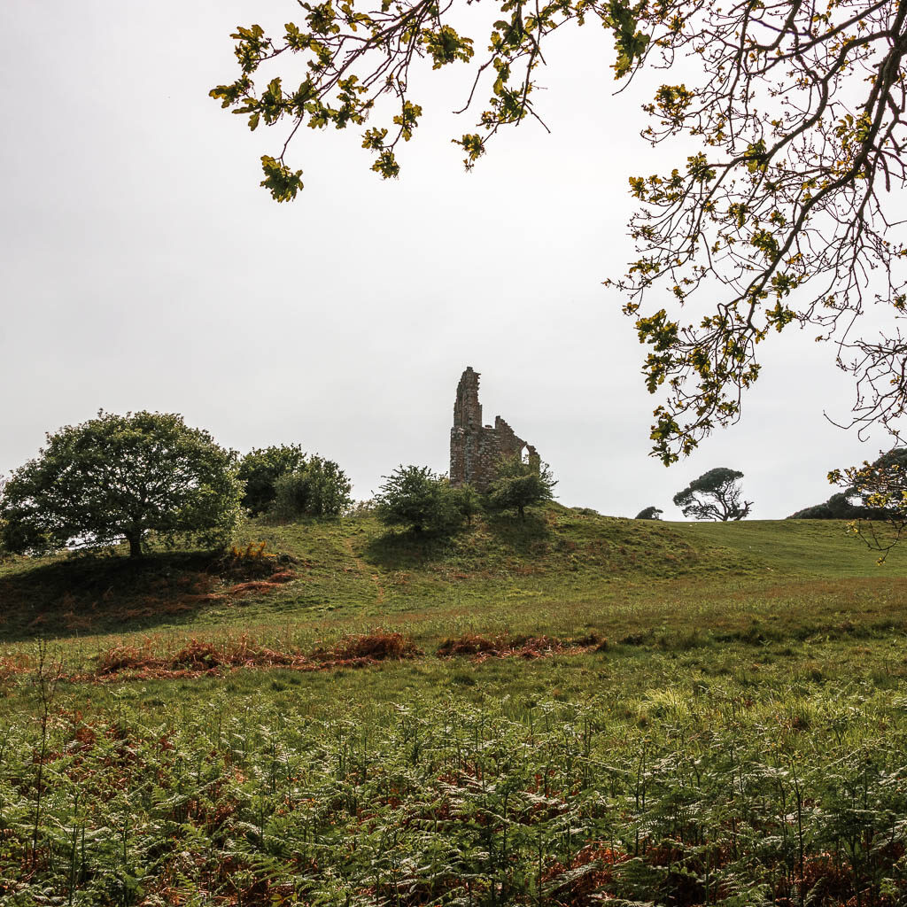 Looking up the grass hill to some stone ruins.