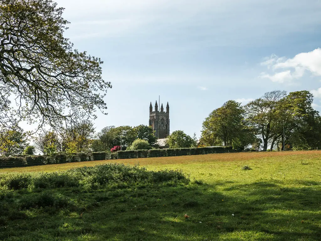 Looking across a grass field towards a church.