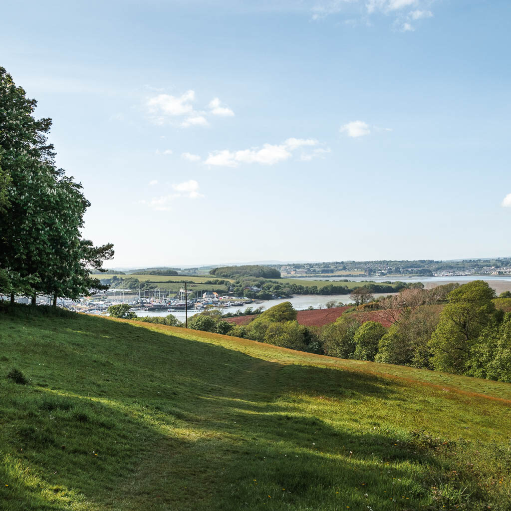 Looking across the grass hill field with the river just visible ahead in the distance. 