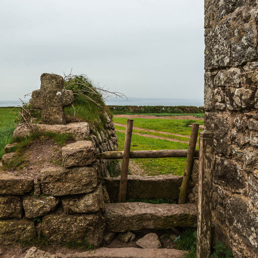 Stone steps leading past the budding on the right, with a stone wall on the left. 