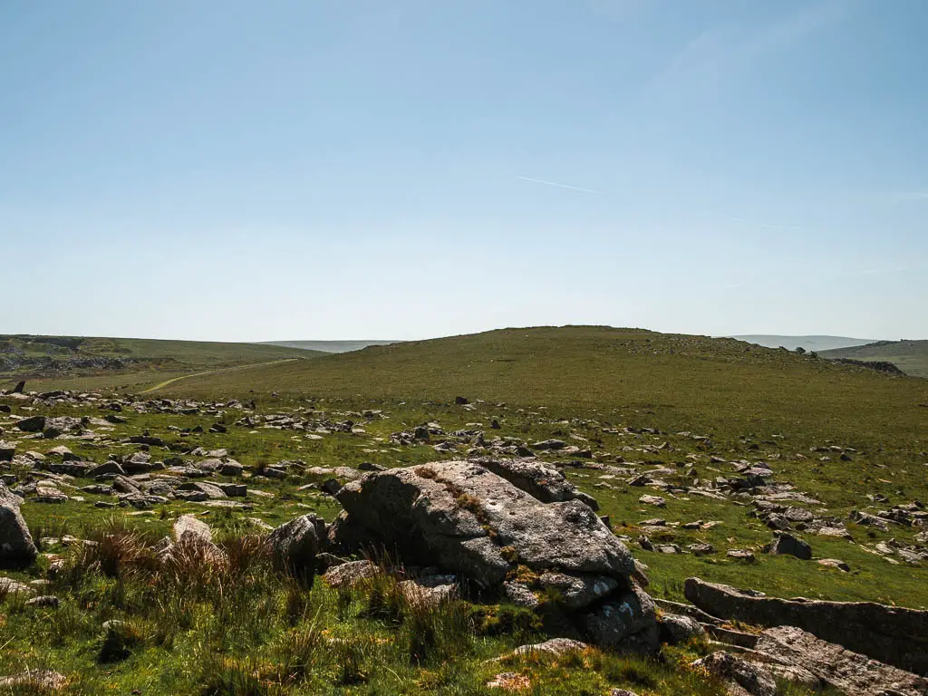 Looking over the rocks to the moor and hill ahead.