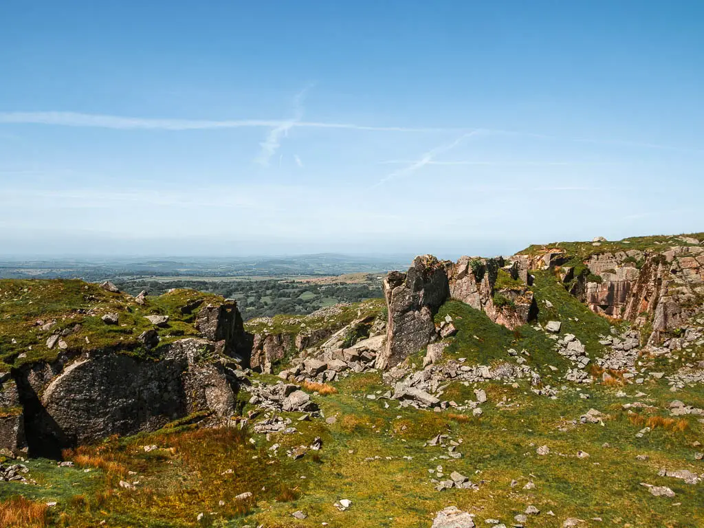 Looking down into the quarry of grass surrounded by rock tors, on the Princetown Railway walk.