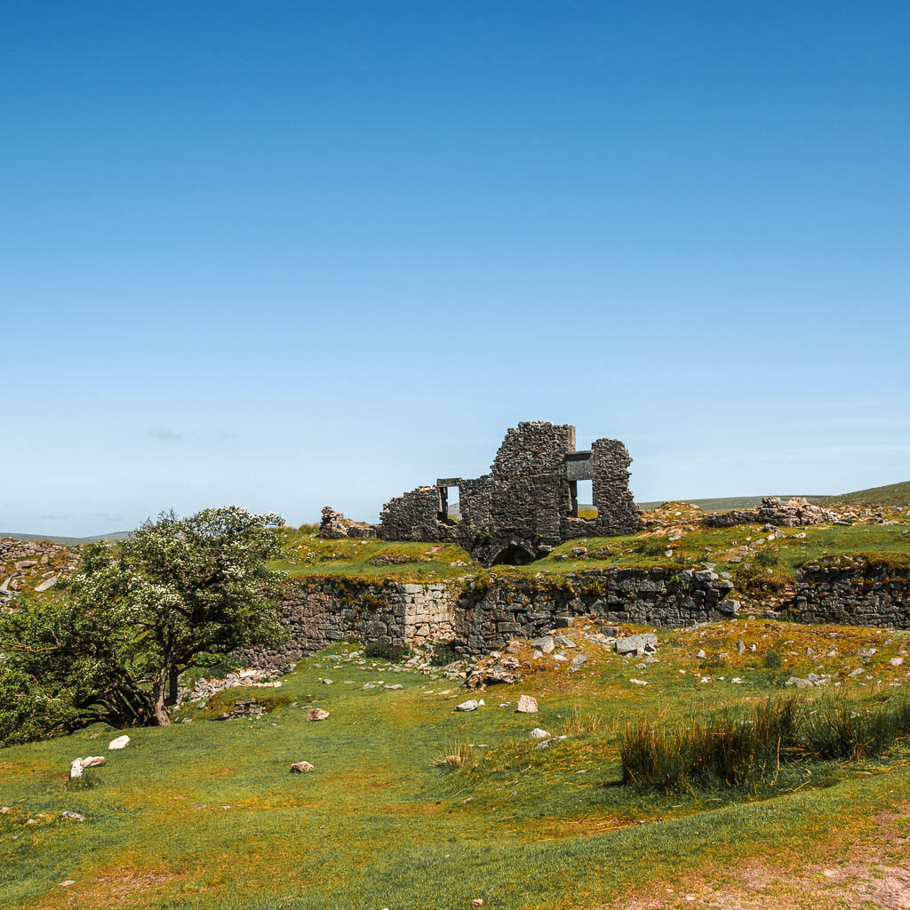 Looking across the grass towards some stone wall ruins.
