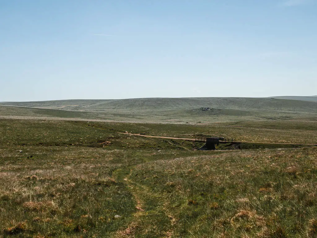 Looking down the grass trail and across the moor, extending out as far as the eye can see.