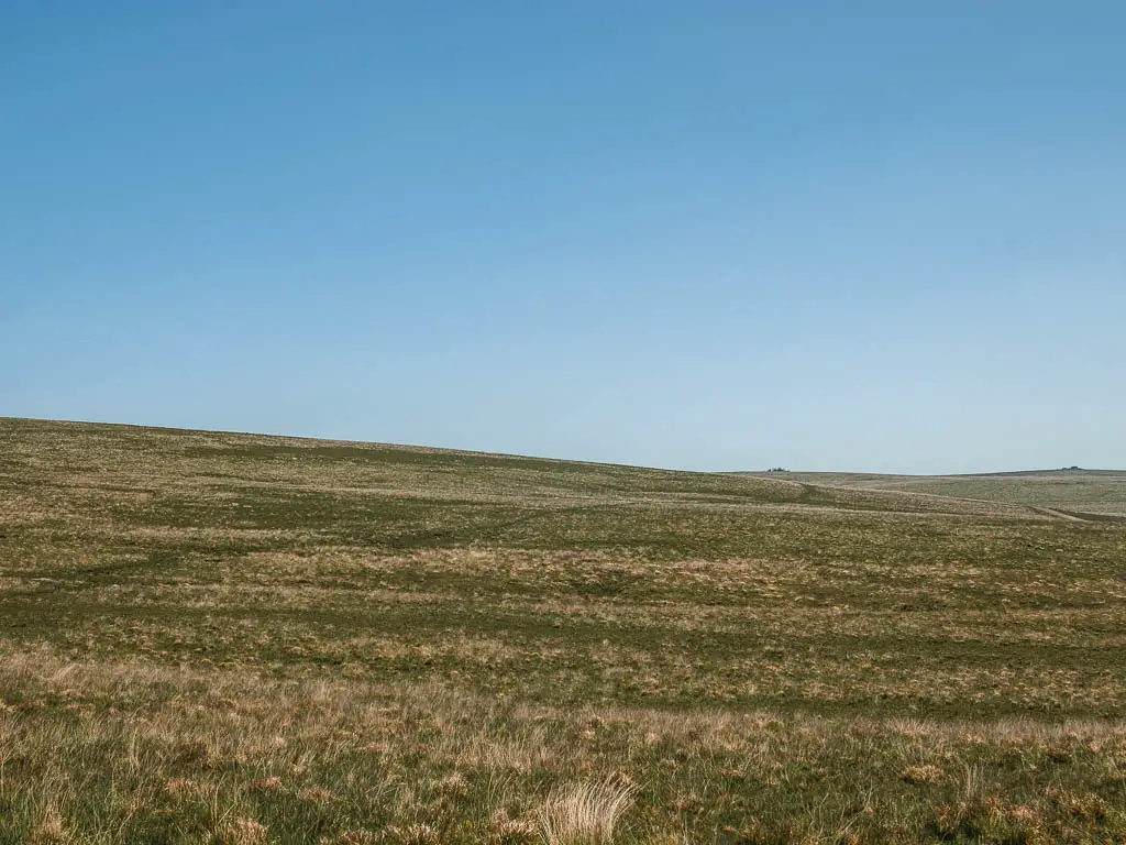 Looking across the moor, with a faint trail running across it in the distance.