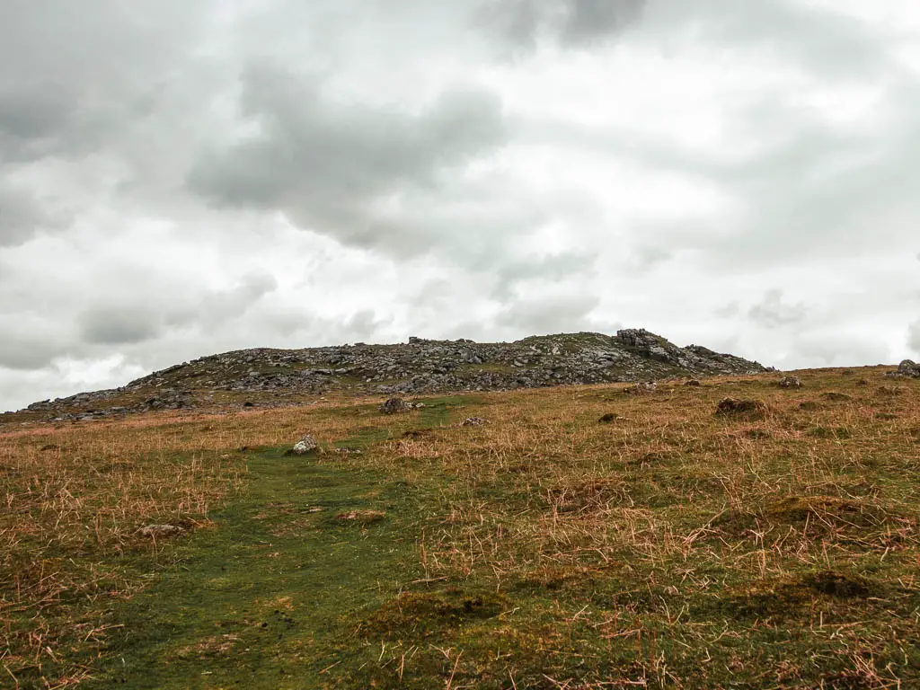 A grass trail leading uphill towards Sheepstor at the top.