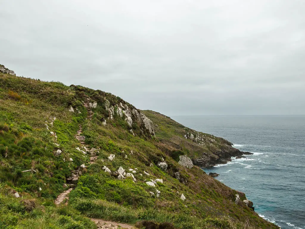 A rocky trail running along the top of the grass covered cliff, on the walk from St Ives to Zennor.