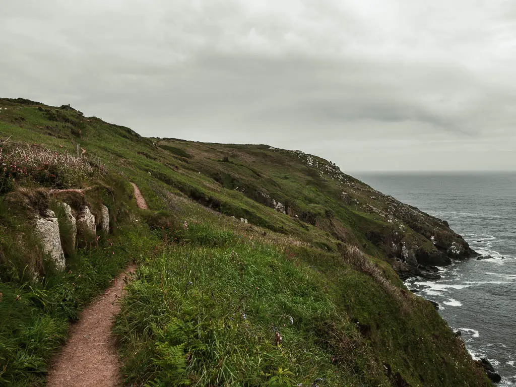 A narrow trail on the edge of the cliff on the left, with a steep drop to the right. 