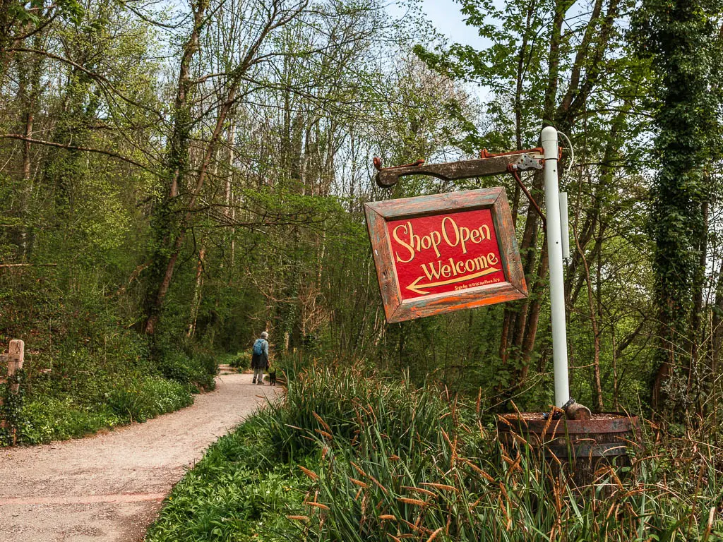 A handing red sign pointing to the shop.