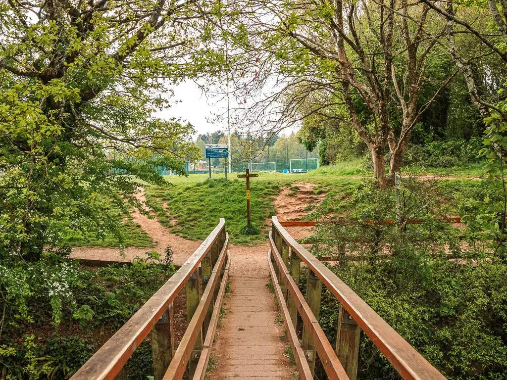Looking along a wooden bridge with wooden railings.