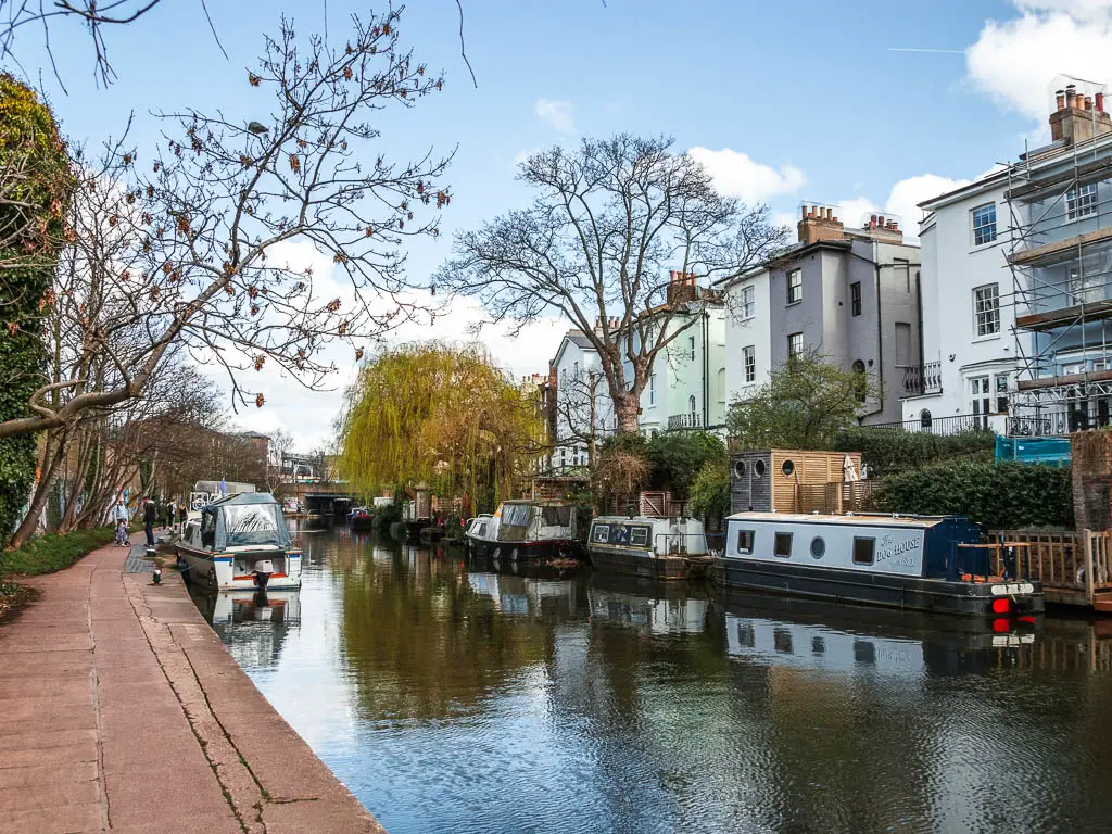 the canal lined with barges, and residential homes on the other side.