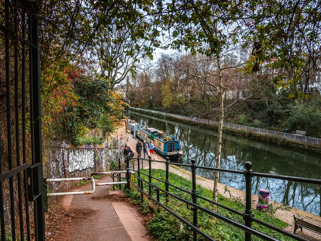 Looking down the path leading to the water, with a few people walking alongside it.