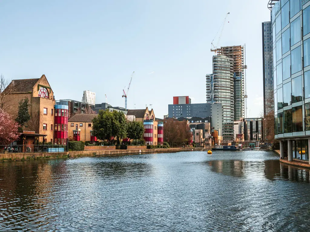 Looking along a large opening of the canal, with brick apartments on the left side, glass apartments on the right, and a tall skyscraper ahead. 