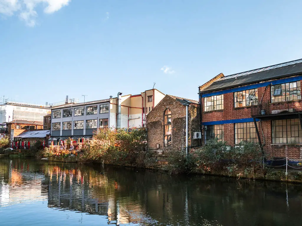 Looking across the water to a mix of old brick warehouse buildings. 