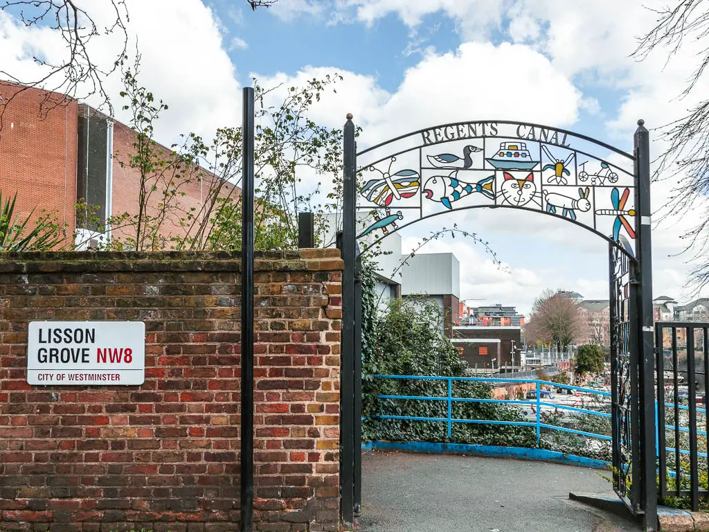 A brick wall and back metal archway entrance to the path, to take you down to walk alongside the Regents Canal 