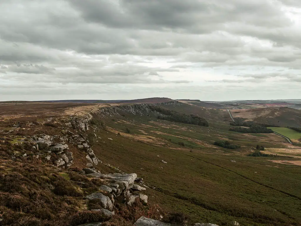 Looking along the top and side of the rock face of Stanage Edge as it leads down the hill on the right.