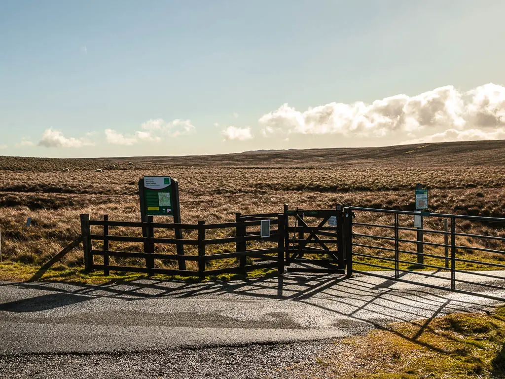 A wooden and metal gate in the road.