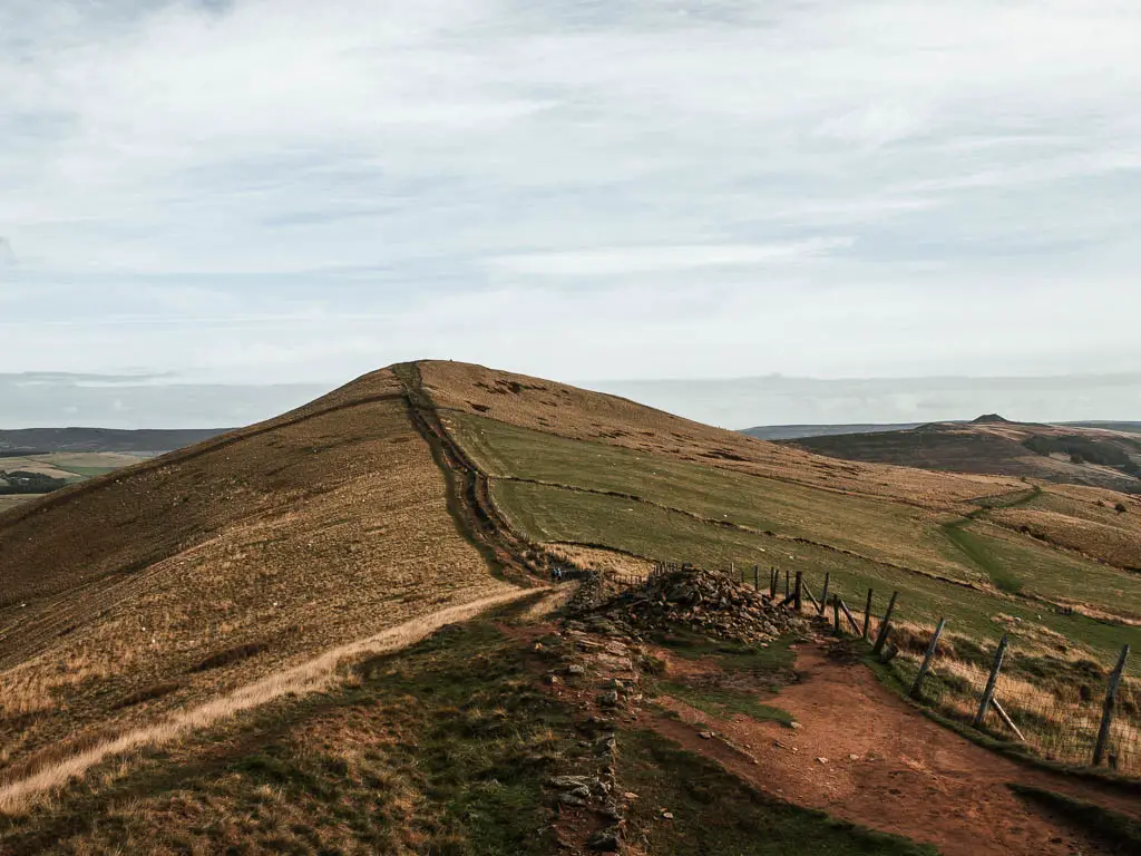 A dirt path leading down, then up a hill on the walk along the Great Ridge from Mam Tor.