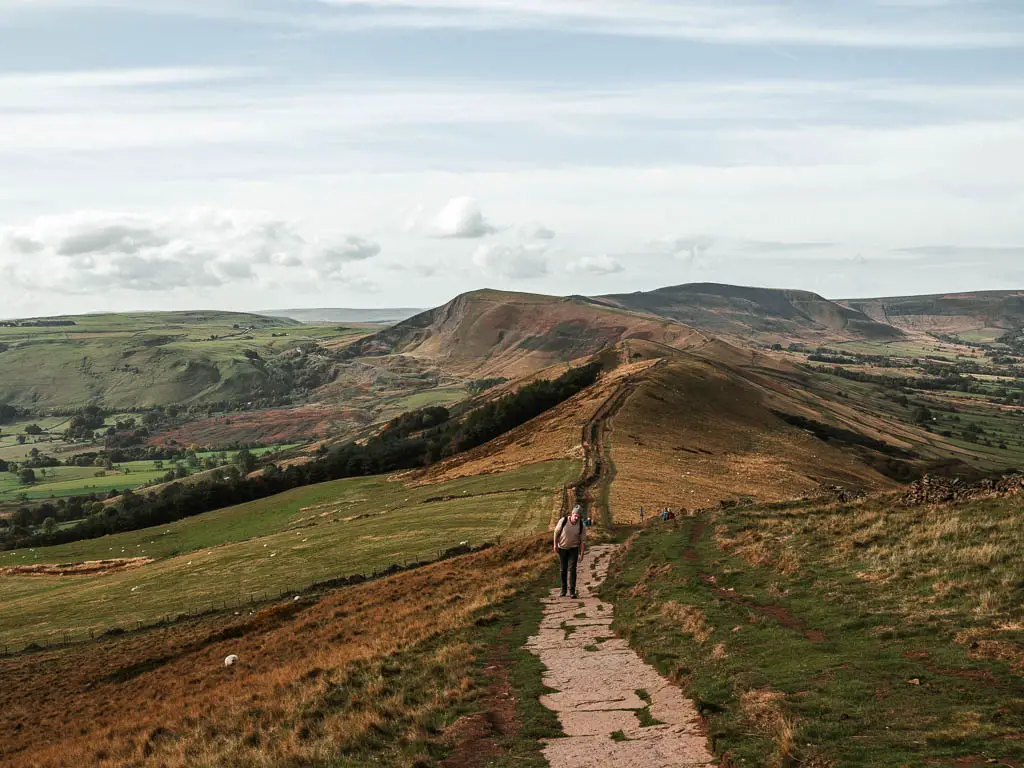 Looking along the great ridge towards Mam Tor, with a man walking along it.