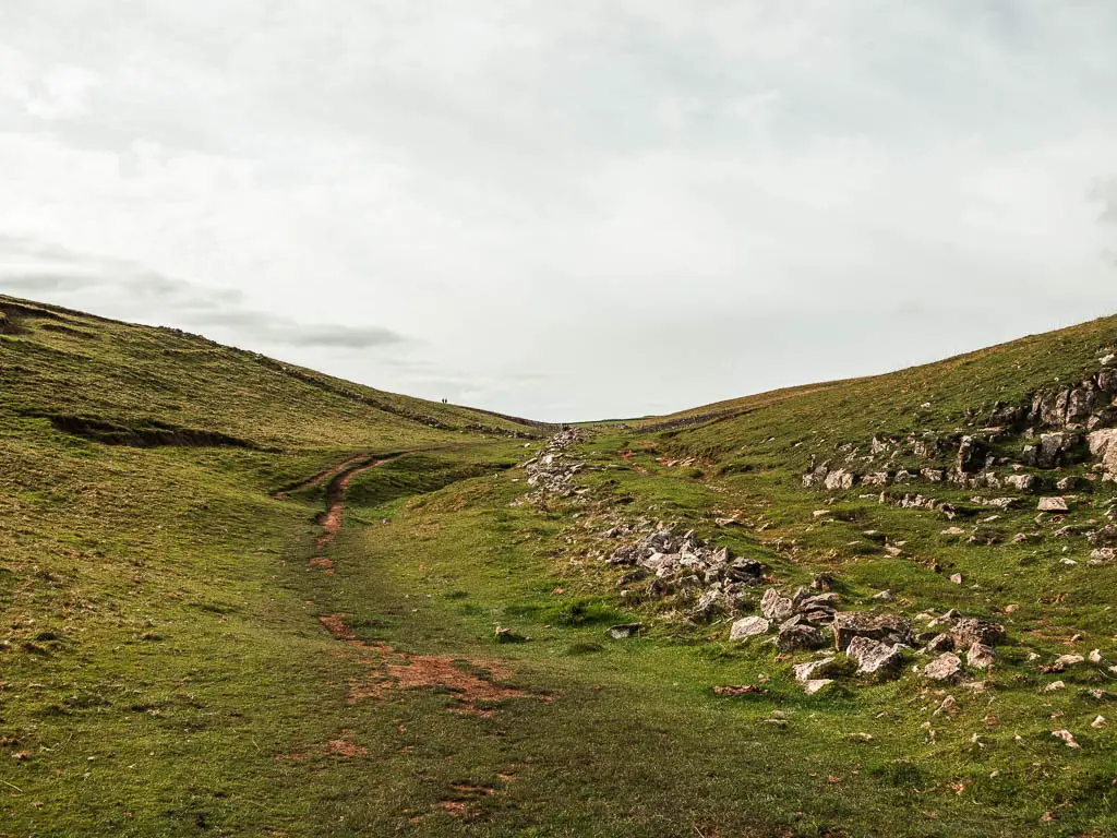 A small dirt path running through the small dip in the hill.