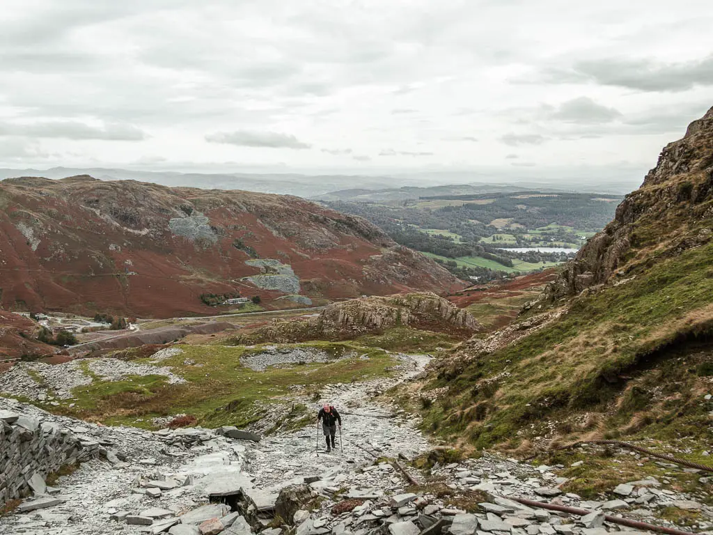 A man walking up the hill on the slate rock path, on the way to the old man of coniston.