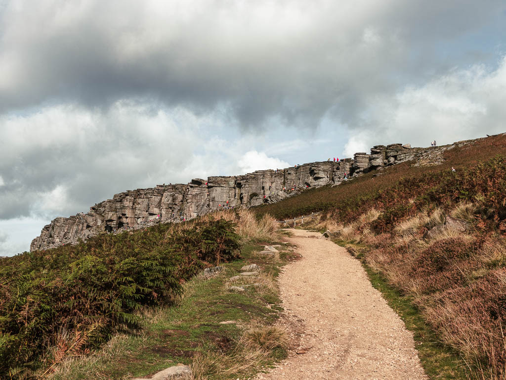 A wide trail leading up to the rock face of Stanage Edge at the start of the walk.