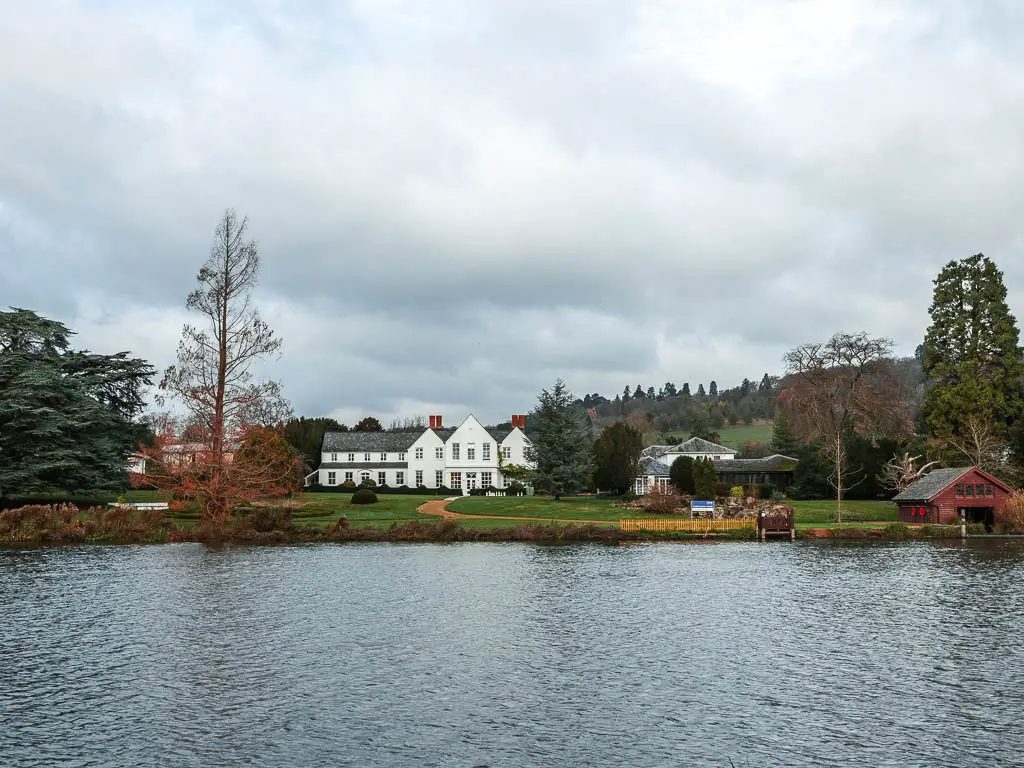 Looking across the river thames, to a large whit Manor House on the other side.