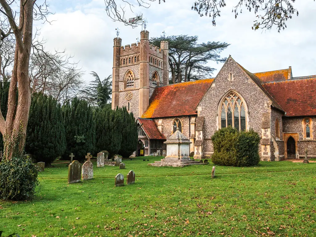A grass graveyard, with a church on the other side, in Hambleden.