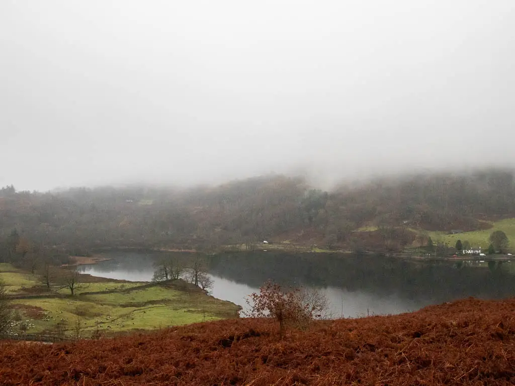 Looking down the hill to Rydal Water on the walk to Rydal Cave. There is low hanging fog above the water.