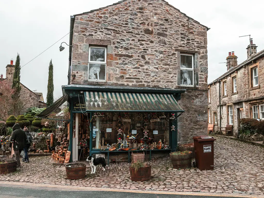 A stone and flint building with a trinket shop underneath in Grassington. 