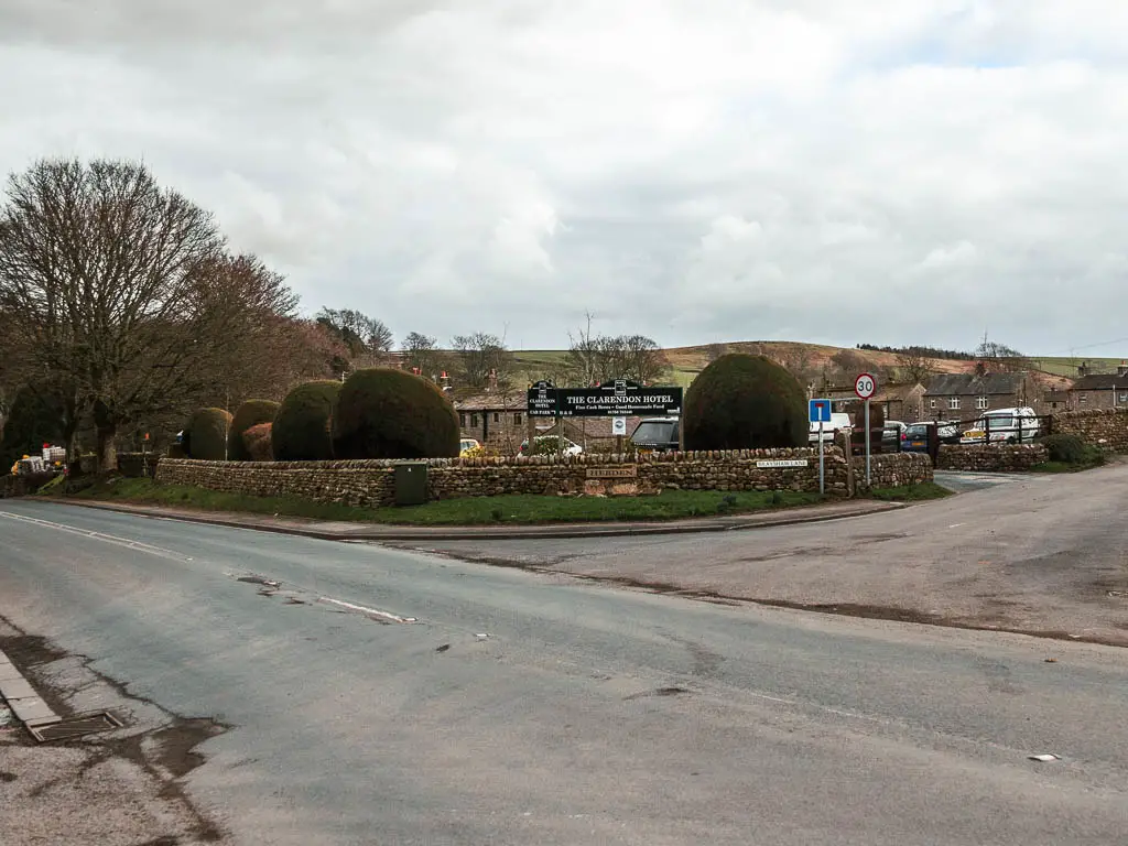 Looking across the road towards a car path, and the sign saying 'the Clarendon Hotel'.