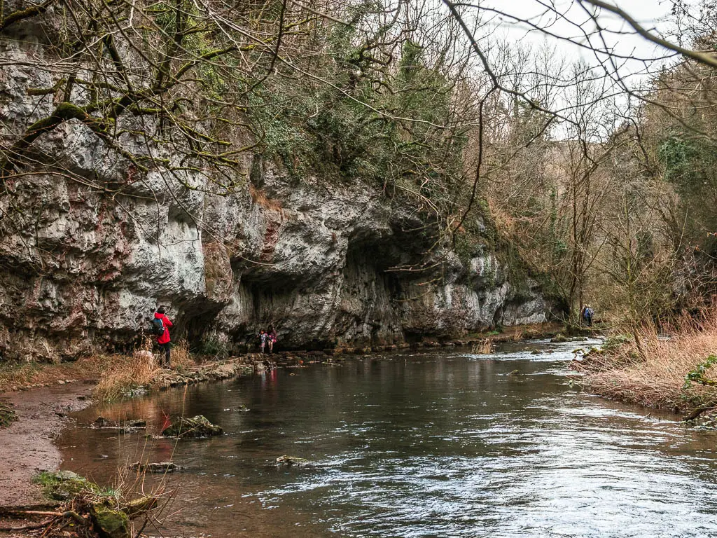 The river leading to the stepping stones under the cliff side of Chee Dale, with some children walking along them