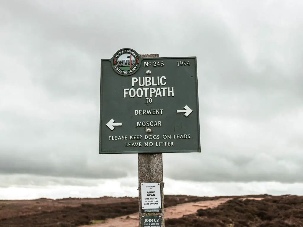 A sign on a wooden stick sating 'public footpath'.