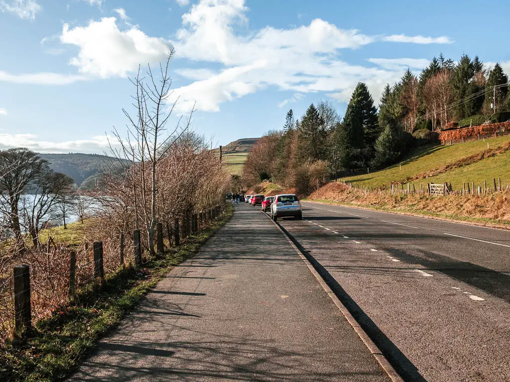 The road with cars parked along the side of it.