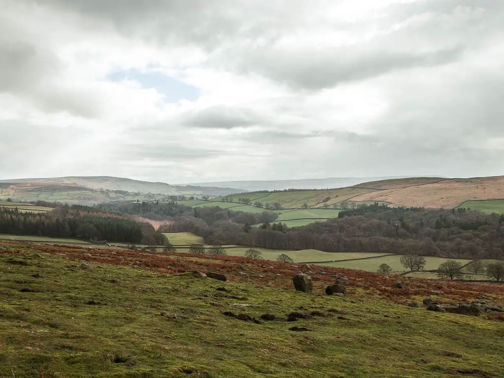 Looking down the grass field to the underling hills in the distance.