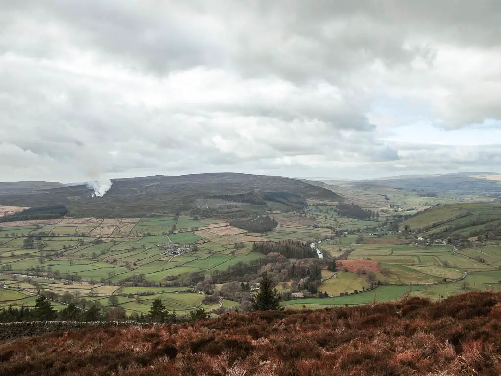 Looking down into the valley of green patchwork fields on the walk up to Simon's Seat.