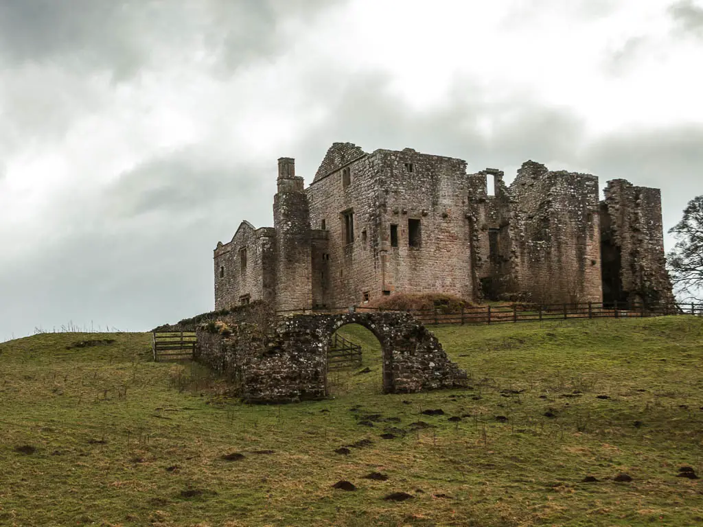 The ruins of Barden Tower on the top of a green grassed hill field, at the start of the walk to Simon's Seat and the Valley of Desolation.
