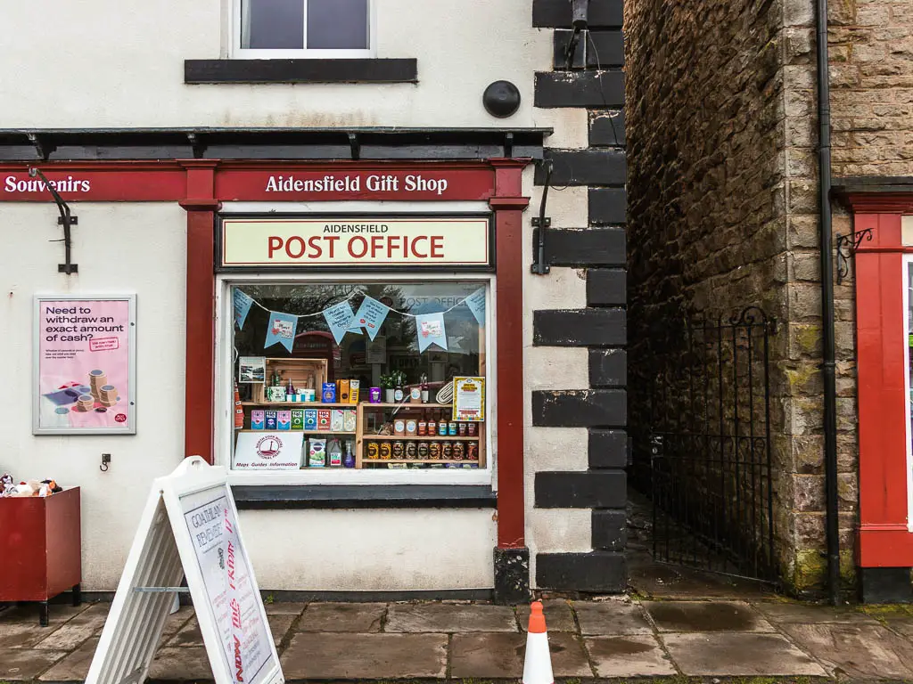 A post office building in Goathland, with a window display of products, and bunting. 