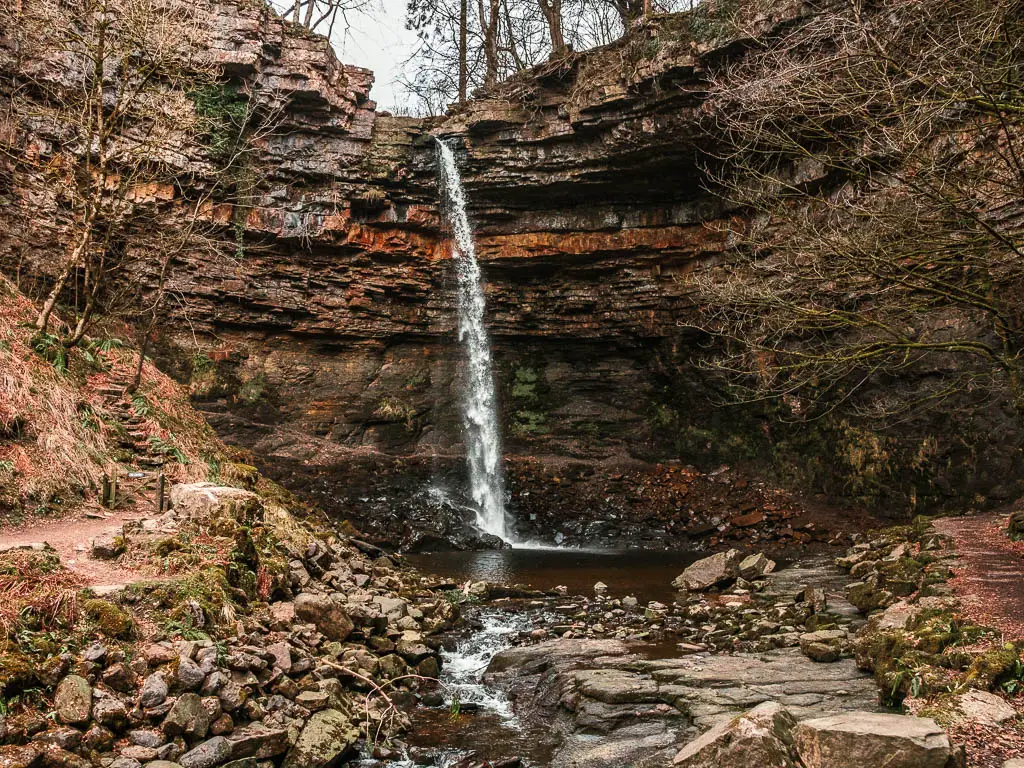 Hardraw Force, a tall thin waterfall gushing over and down a rugged cliff part way through the walk, in the Yorkshire Dales.