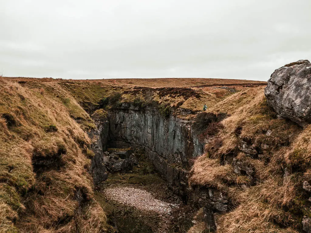 A deep cavern with grass on the top.