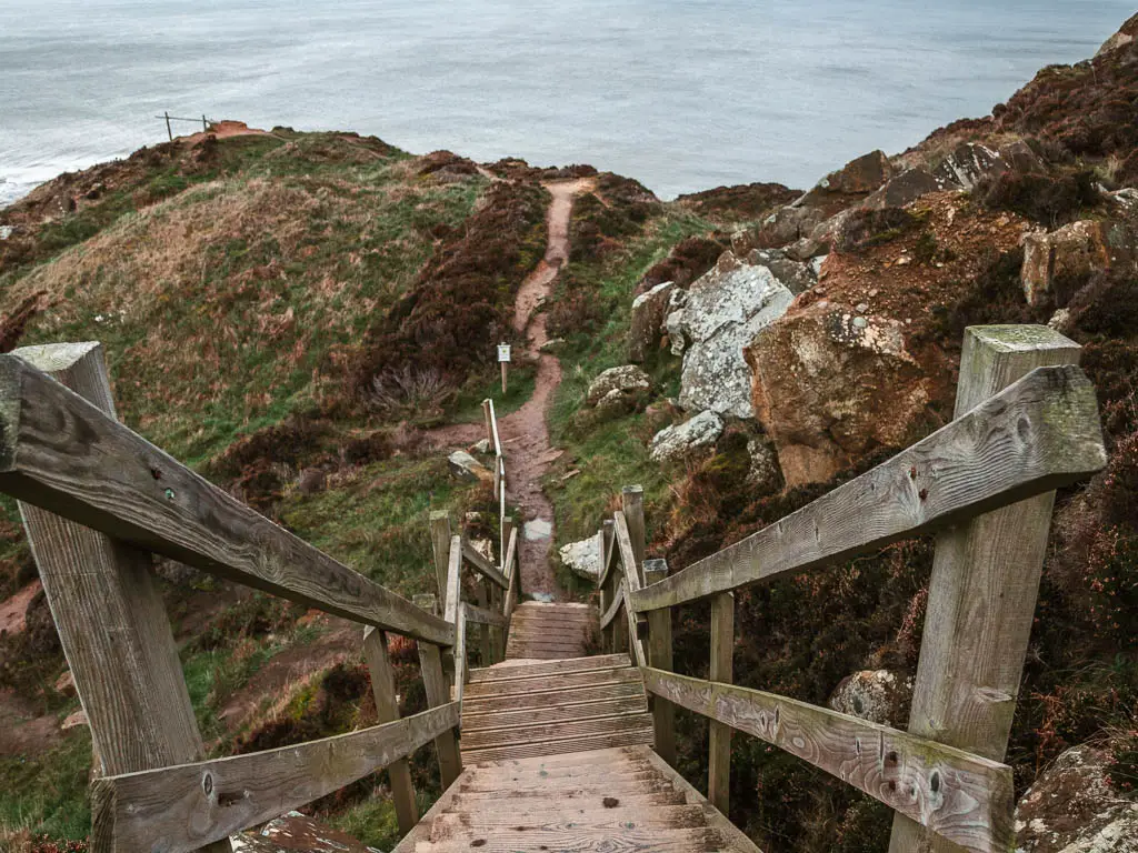 Steep wooden steps leading down to the the rugged hill and trail on the Robin Hood's Bay and Ravenscar circular walk.