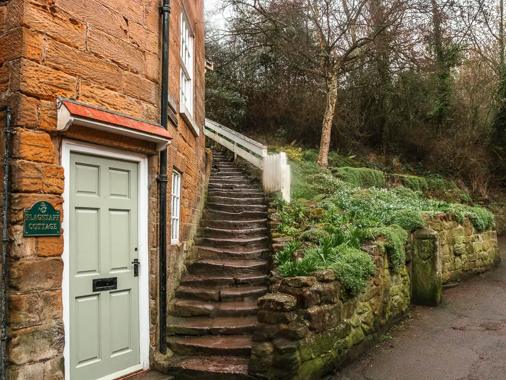 Cute stone steps winding around the side of a stone house on the Robin Hood's Bay and Ravenscar walk.