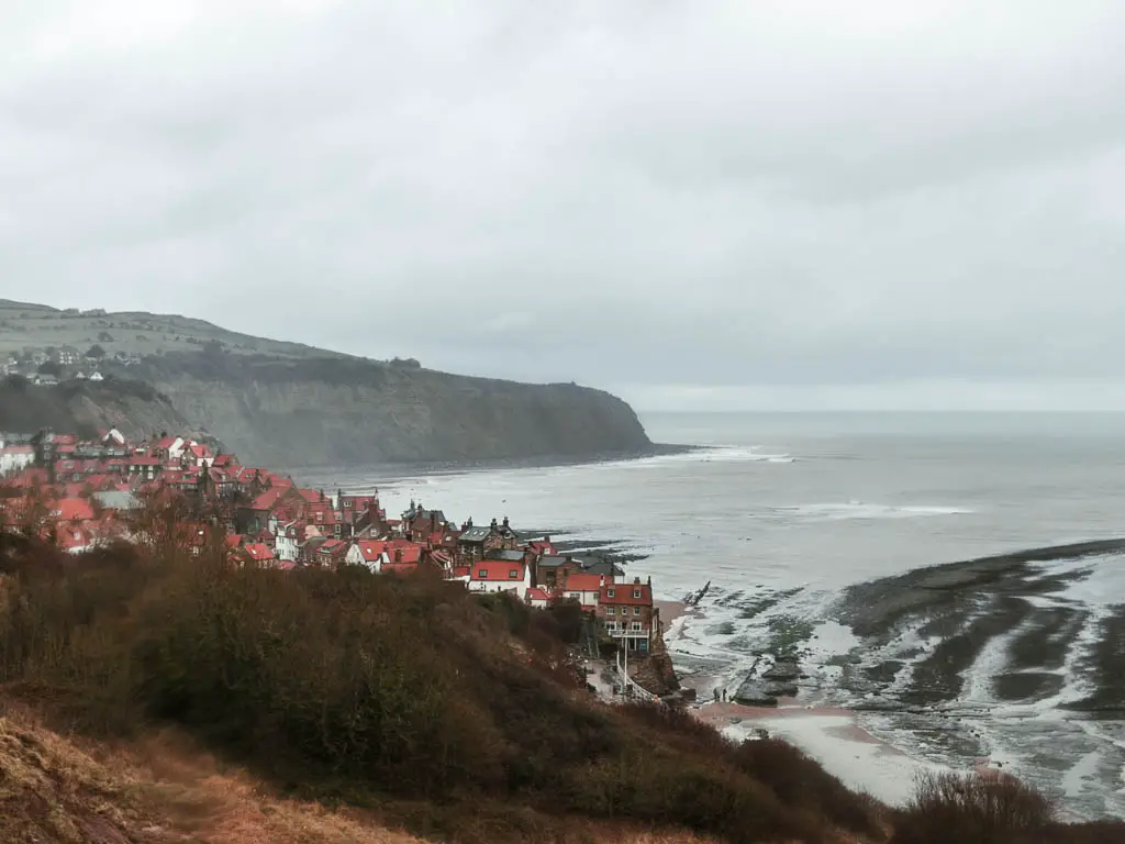 Looking down and over to the red rooftops of Robin Hood's Bay by the sea, near the end of the circular walk to Ravenscar.