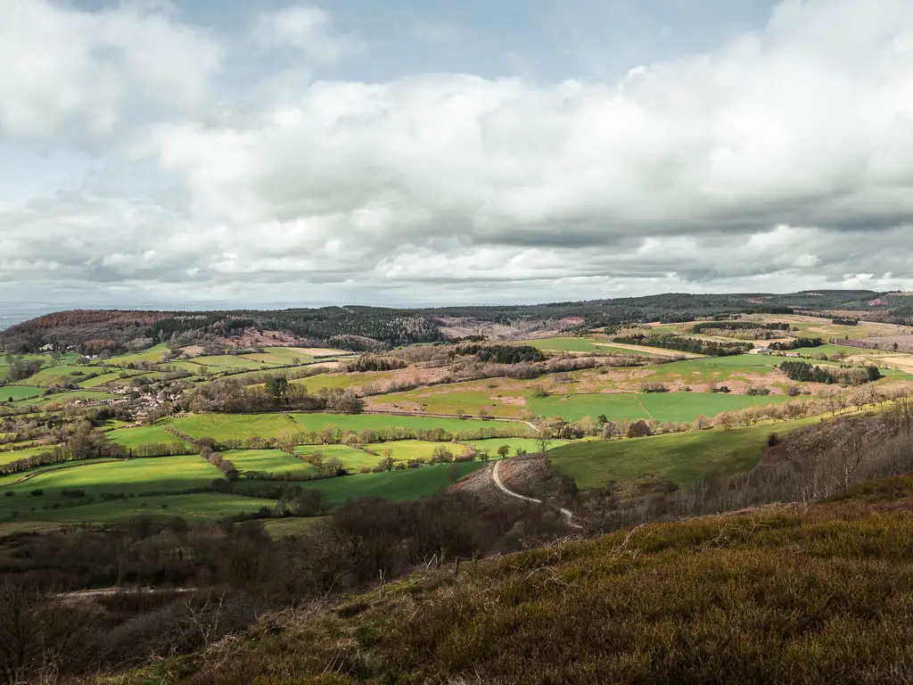 Looking down and across a vast expansion of fields, in tree lined patches, on the circular walk to Sutton Bank.