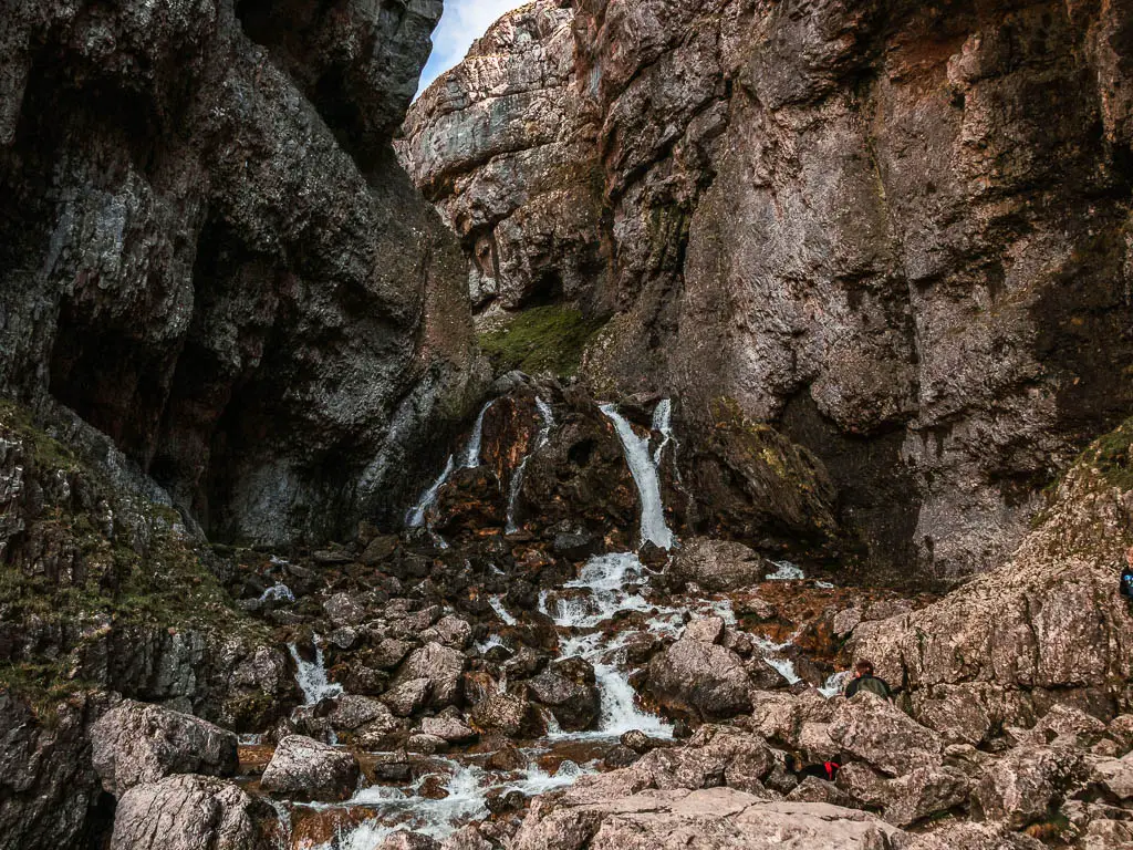 A waterfall running down through the cliffside of the Gordale Scar Gorge, on the circular walk to Malham Cove.