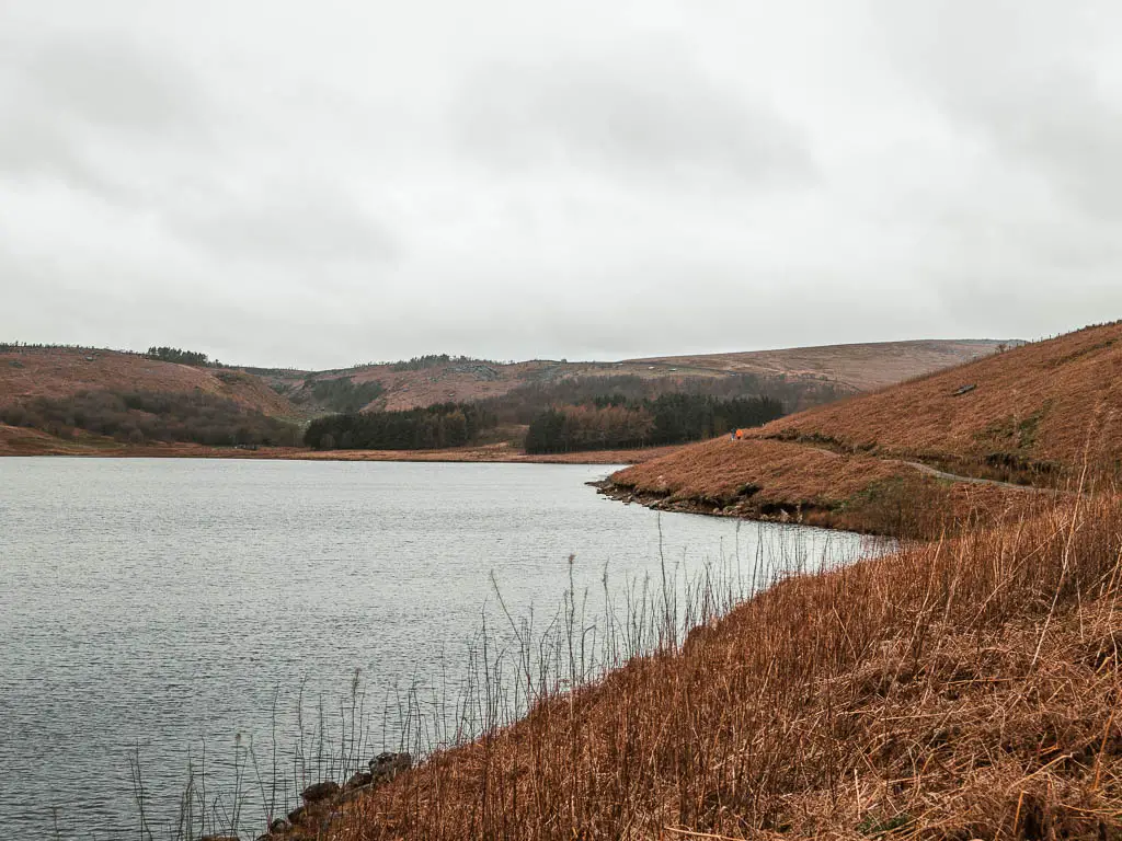 the reservoir on the left and a hill side on the right, with a path running along the side of it. 